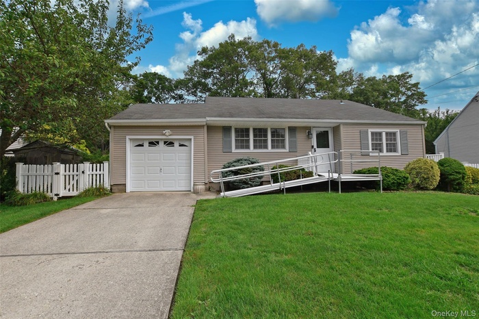 Ranch-style home featuring an attached garage and concrete driveway