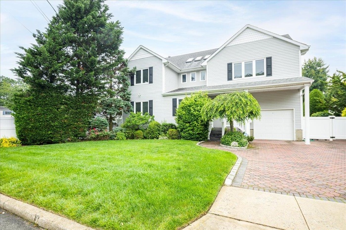 View of front of home with a garage, decorative driveway, and a shingled roof