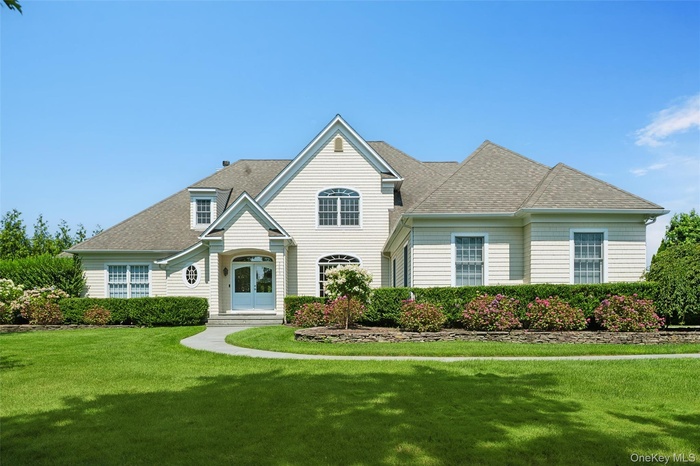 View of front of home with roof with shingles and a front yard