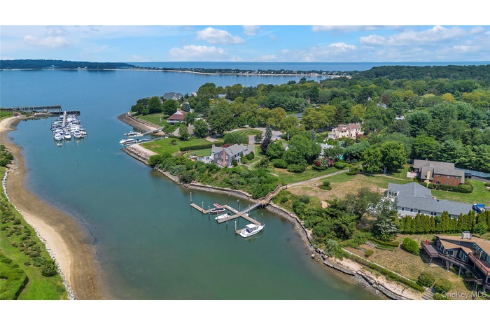 Aerial overview of property's location with a nearby body of water and a marina