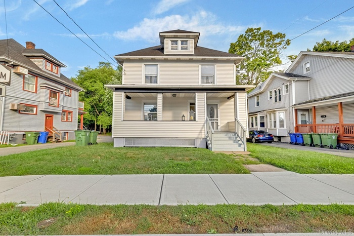 American foursquare style home featuring a front lawn