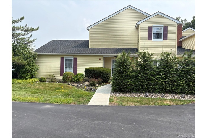 View of front facade with roof with shingles and a front yard