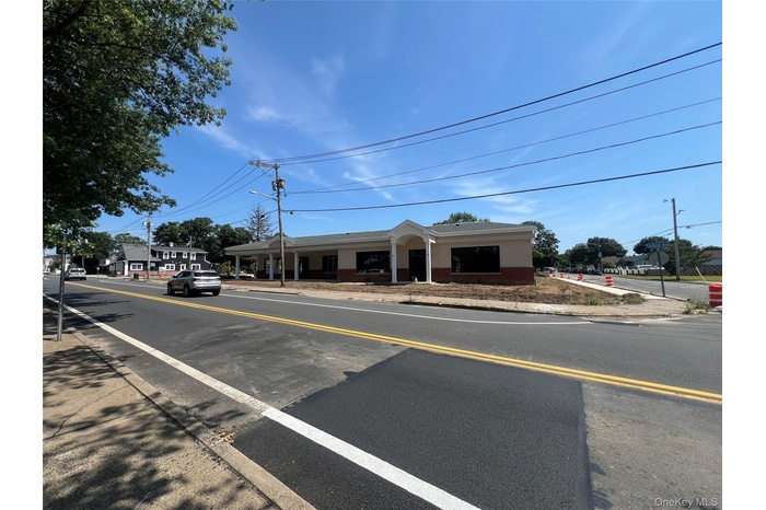 View of asphalt road with street lighting, sidewalks, and curbs