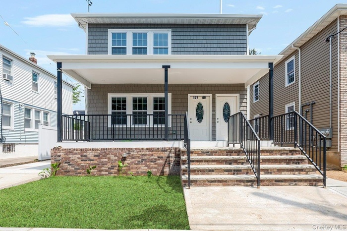 View of front facade with covered porch and a front yard