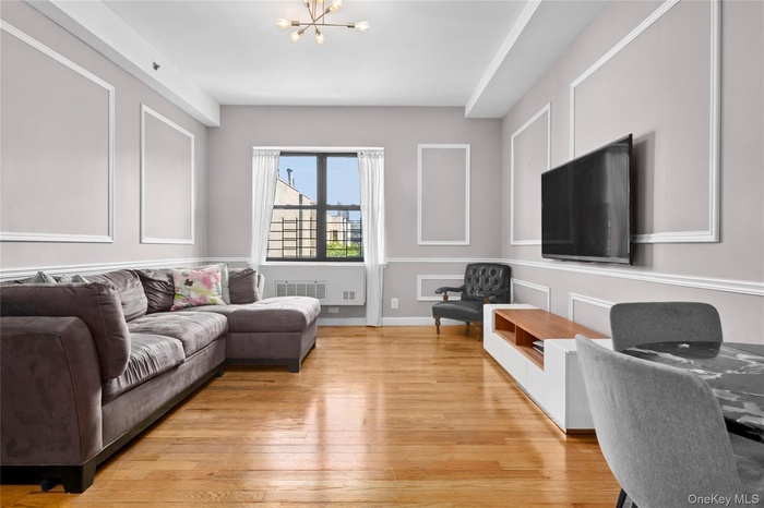 Living room with light wood-type flooring and a chandelier