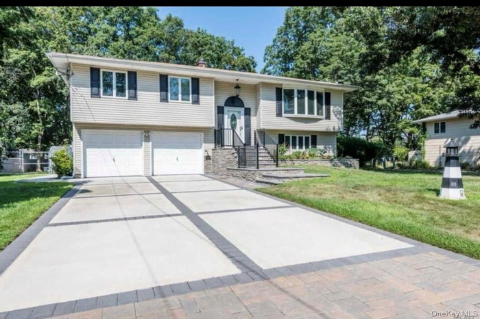 Split foyer home with a front lawn, a garage, and driveway