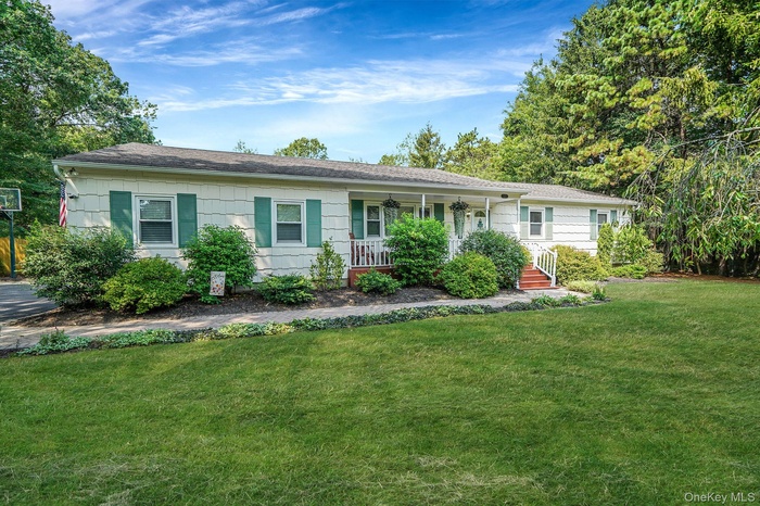 Ranch-style house with covered porch, a front yard, and roof with shingles