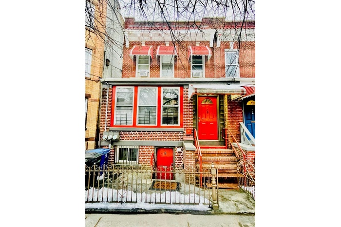 Townhome / multi-family property featuring a fenced front yard and brick siding