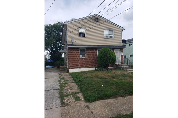 View of front of home with brick siding and a front yard