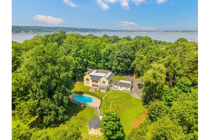 View from above of property featuring a pool area and a large body of water