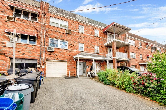 View of apartment building / complex with driveway and a garage
