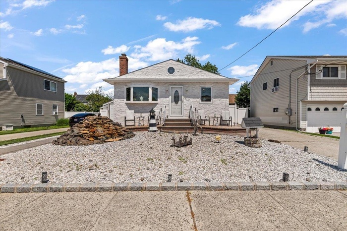 View of front of property featuring a chimney and brick siding