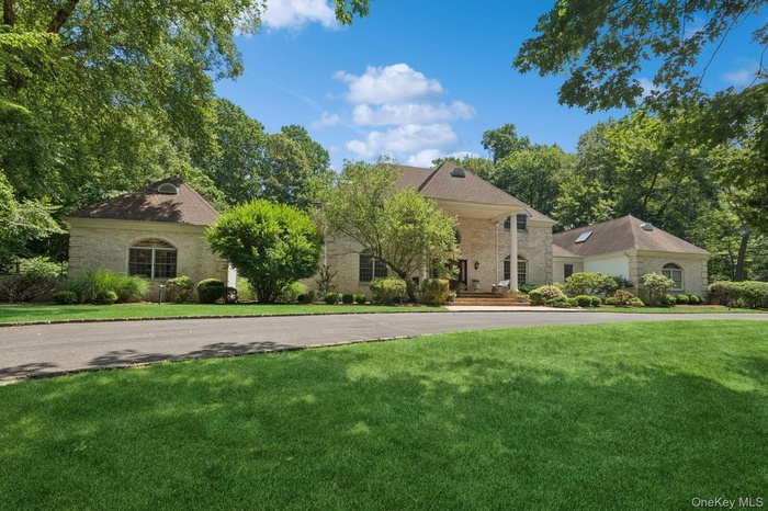 View of front of home with a front yard and circular driveway
