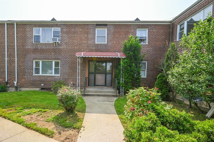 View of front facade with brick siding and a front yard