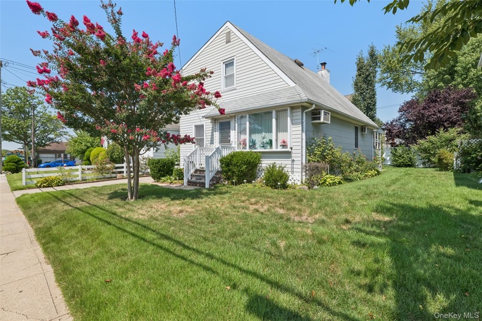 View of side of home with a chimney, a yard, and a shingled roof