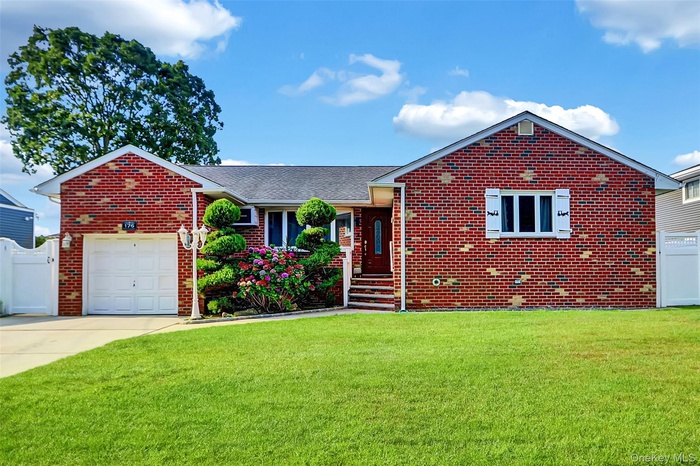 Single story home with driveway, brick siding, an attached garage, and a shingled roof
