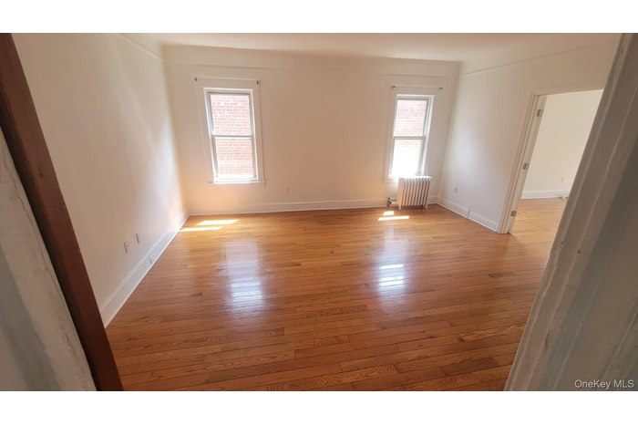 Spare room with light wood-style flooring and radiator heating unit