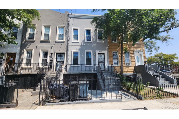 View of front of house featuring stucco siding, a fenced front yard, and a gate