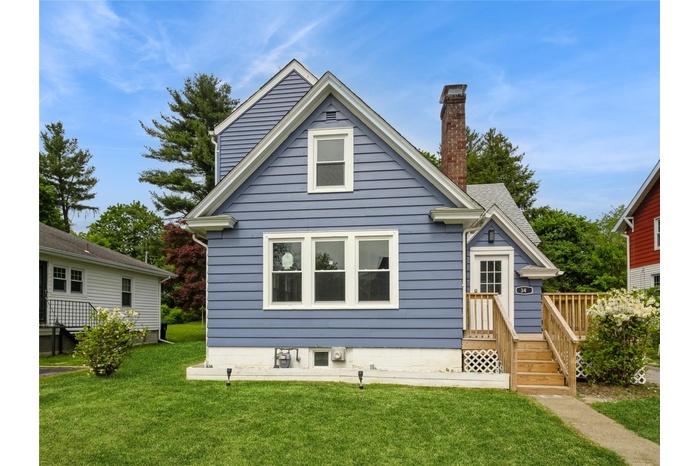 Rear view of property with a lawn and a chimney