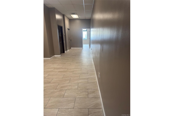 Corridor with a paneled ceiling and wood tiled floors
