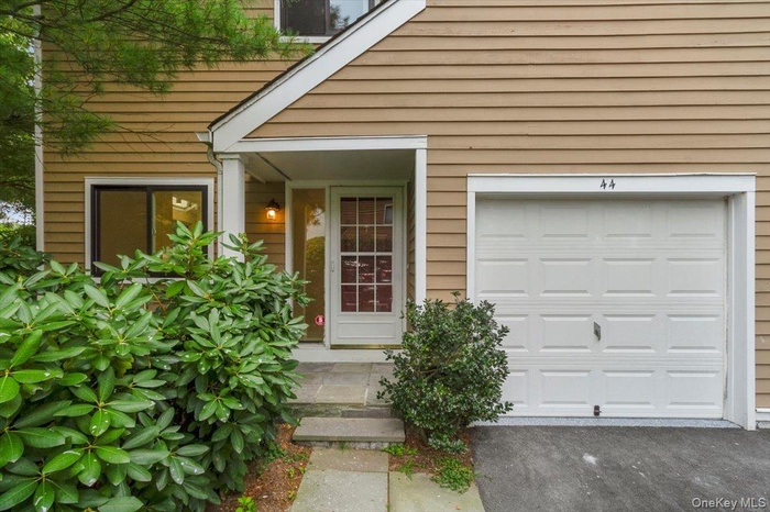 View of exterior entry featuring an attached garage