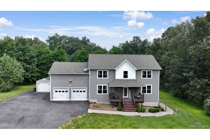 View of front of property with roof with shingles, asphalt driveway, a front yard, and covered porch