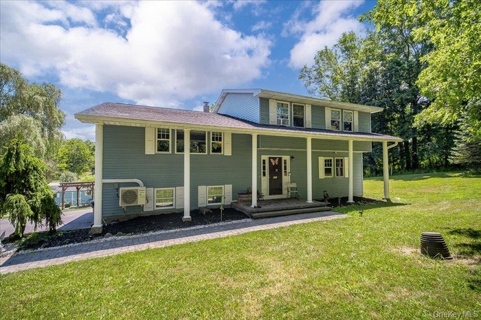 View of front of house with covered porch and a front lawn