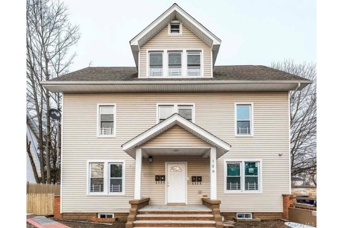 Traditional style home featuring a shingled roof and covered porch