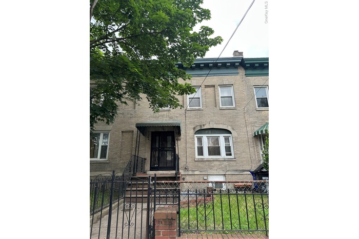 View of front of property featuring brick siding, a gate, and a fenced front yard