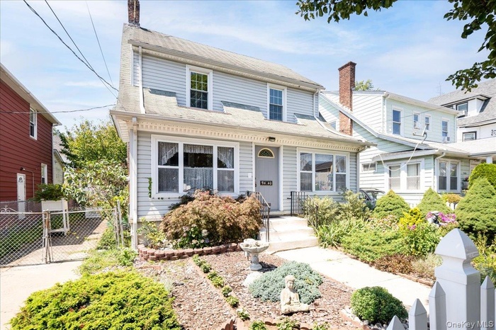 View of front of home featuring a gate and a chimney