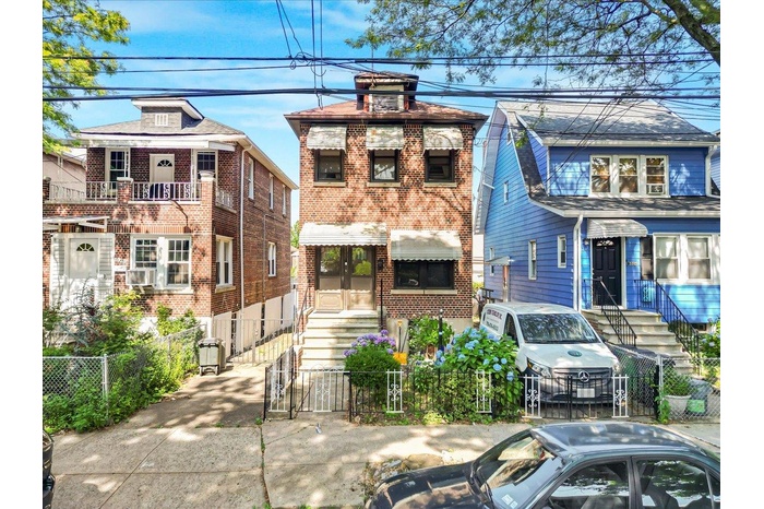 View of front facade with entry steps, a gate, brick siding, and a fenced front yard