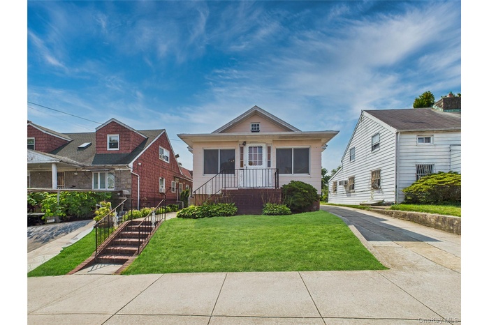 Bungalow-style home featuring a front lawn and stairway
