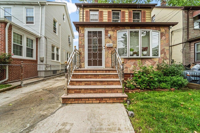 View of front facade with entry steps and stone siding