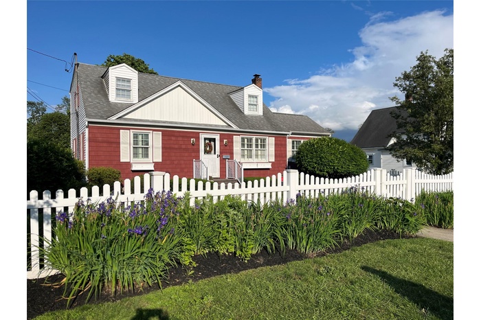 Cape cod-style house featuring a chimney and roof with shingles