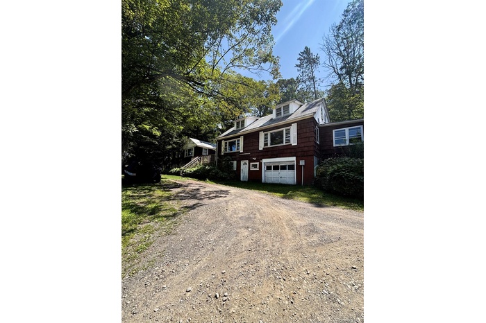 View of front facade with driveway and an attached garage