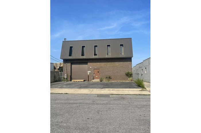 View of front of property featuring brick siding, an attached garage, and driveway