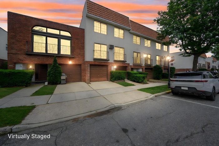 View of front of house with a garage, concrete driveway, and brick siding