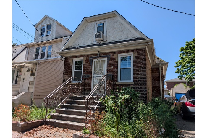 Bungalow featuring brick siding