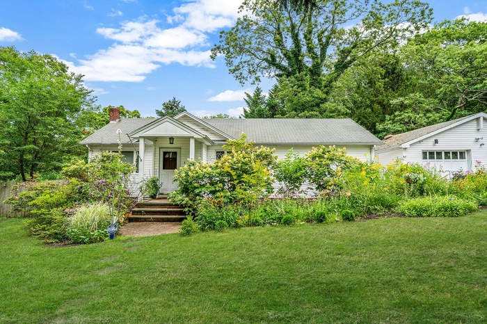 View of front of house with a chimney and a front yard