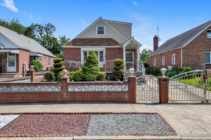 View of front of property featuring a gate, brick siding, and a fenced front yard