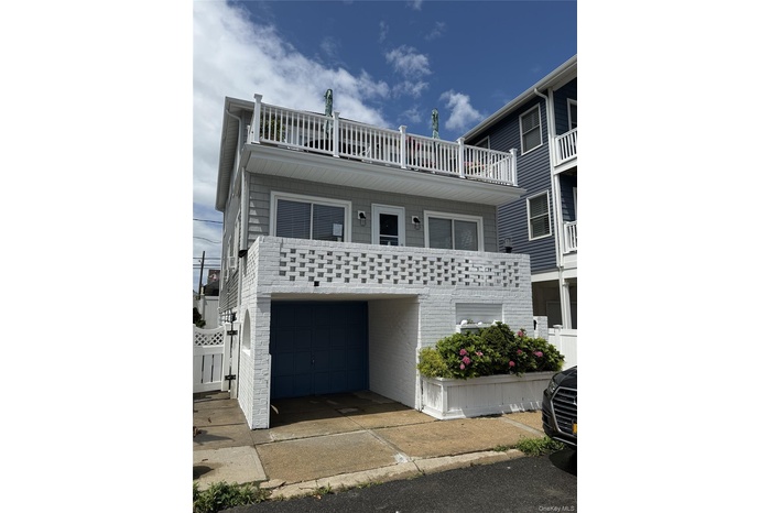 View of front facade with an attached garage and a balcony