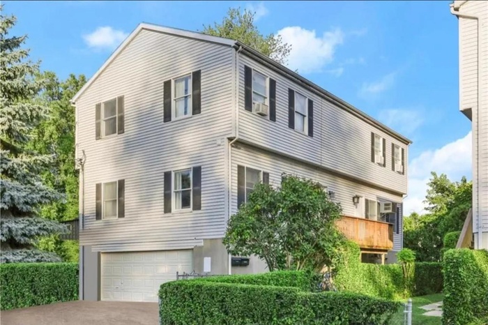 View of side of home featuring concrete driveway and a garage