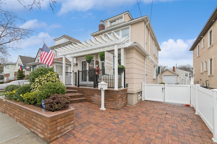 View of front of house featuring a residential view, fence, a gate, and a chimney