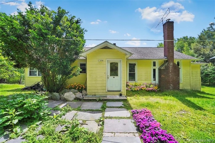 View of front of house featuring a front lawn and a chimney
