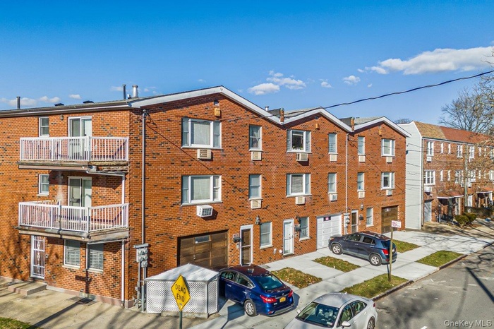 View of apartment building / complex with a garage and driveway