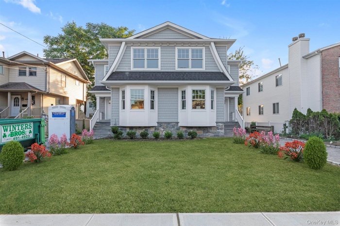 View of front of home featuring roof with shingles and a front yard