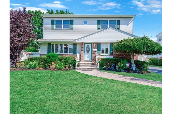 View of front of house featuring a front yard and brick siding