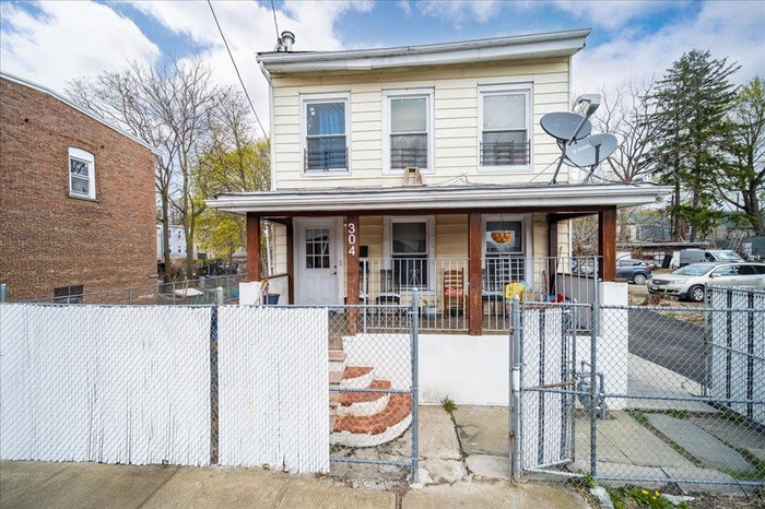 View of front of home featuring a gate, a fenced front yard, and covered porch