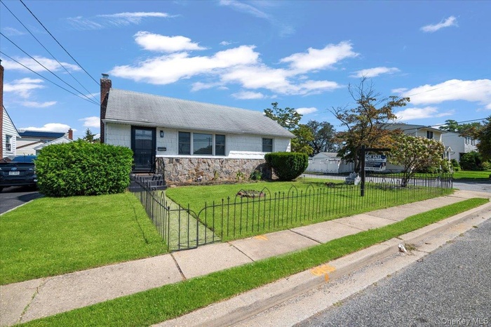 View of front of house featuring a fenced front yard, a chimney, and stone siding