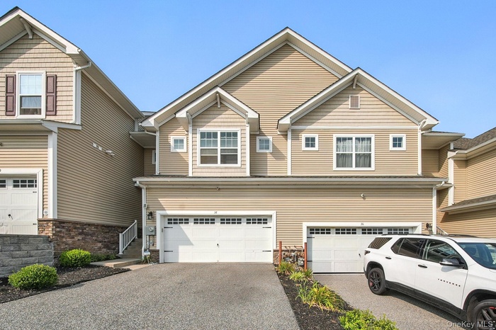 View of front of house featuring an attached 2 car garage and asphalt driveway